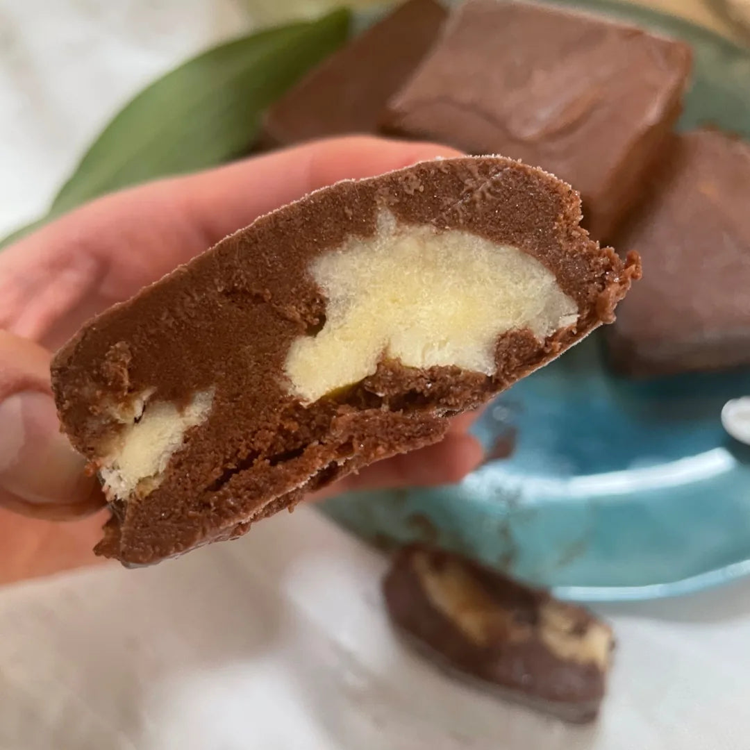 Hand hält Durian Brownie mit heller Durian-Füllung im Anschnitt