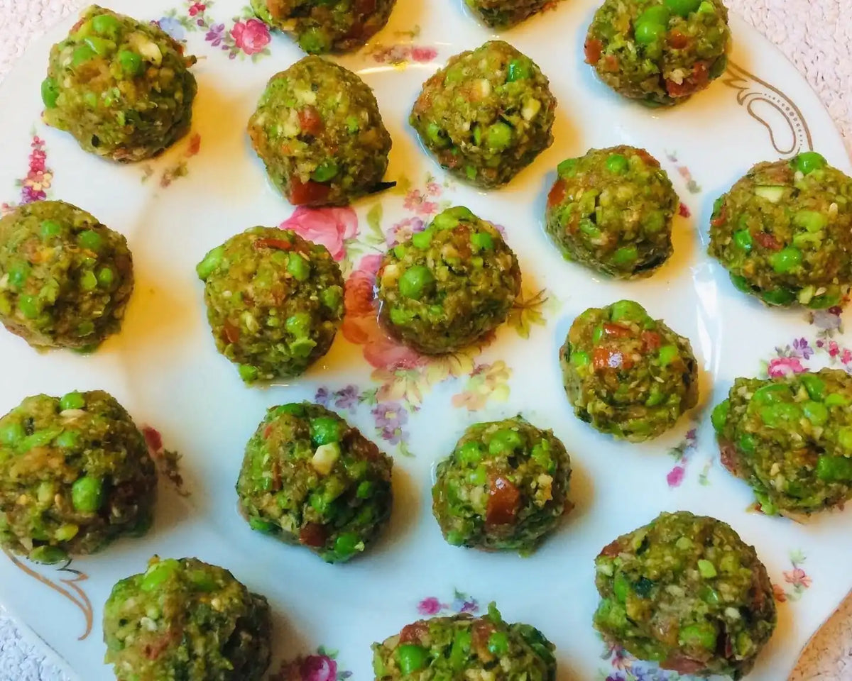 Grüne Erbsen-Bällchen auf geblümtem Porzellanteller