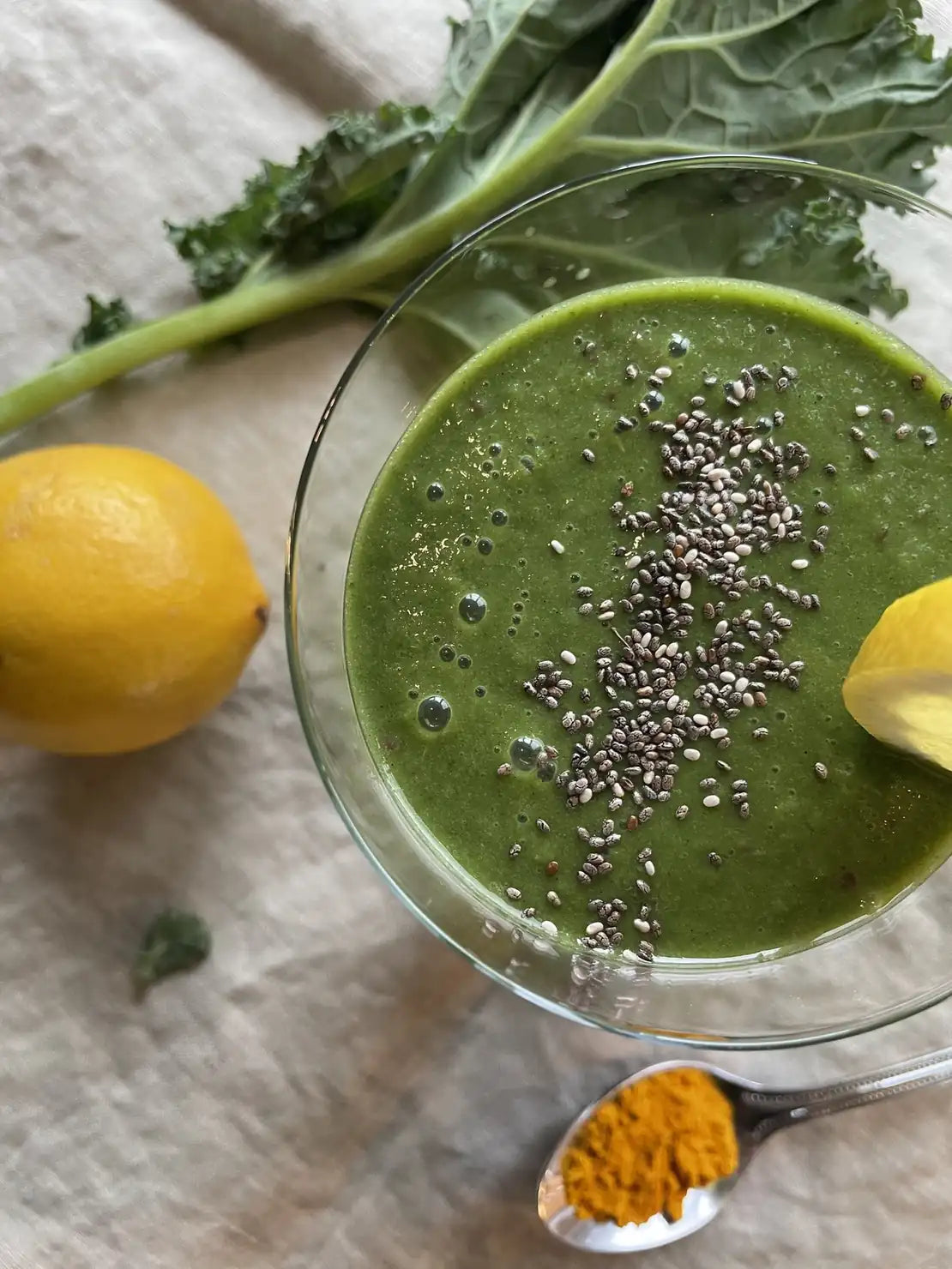 Grüner Smoothie im Glas mit Chiasamen, Zitrone und Grünkohlblatt