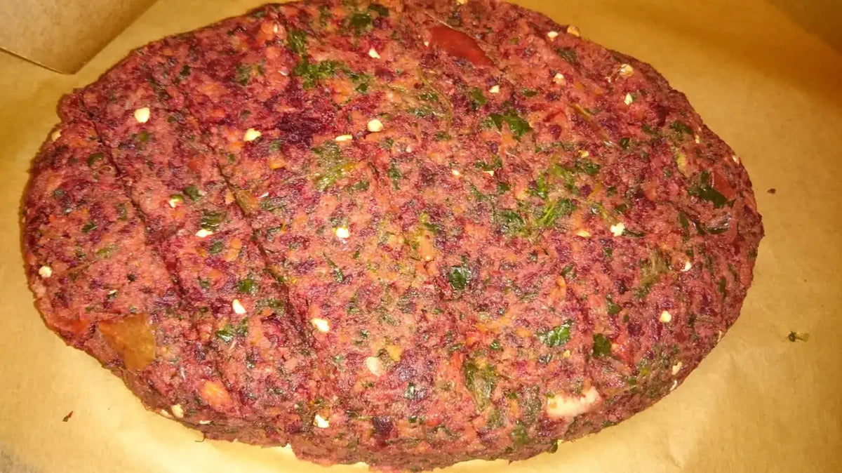 Rötlicher Tresterbrot-Teig mit Kräutern und Kernen auf Backpapier