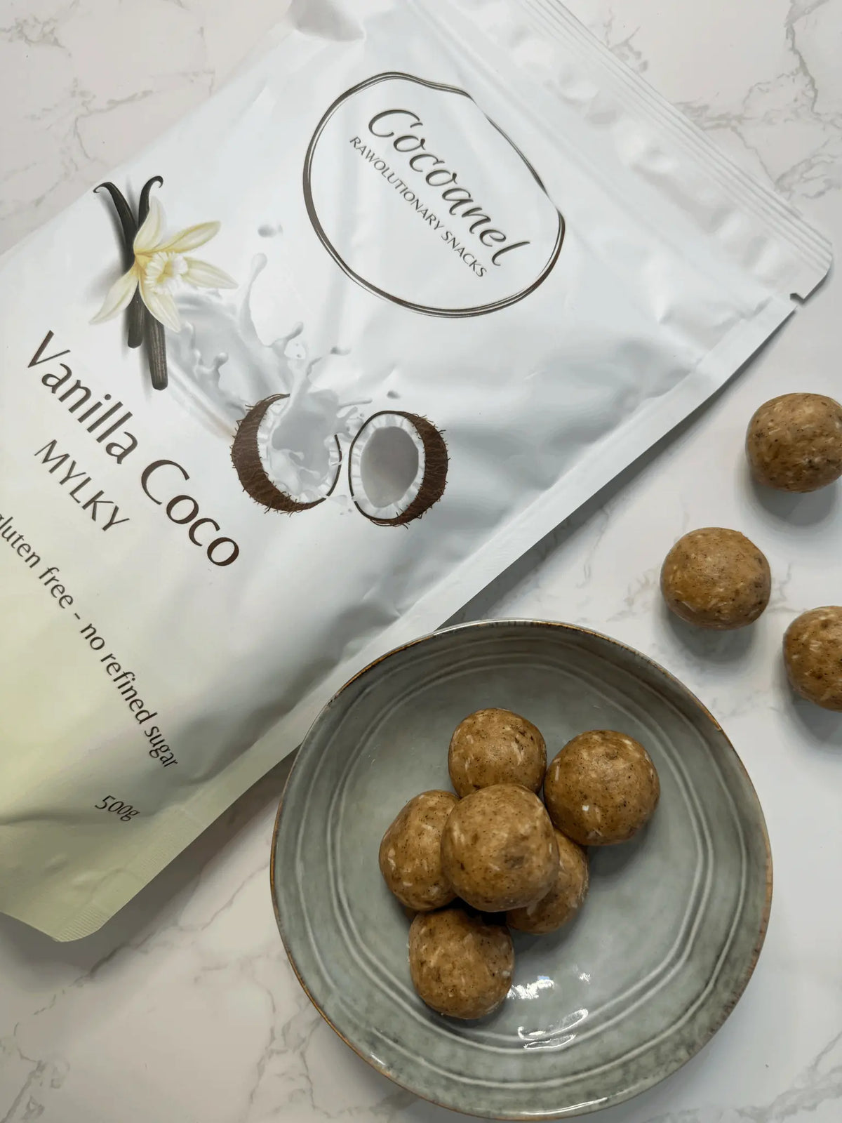 Vanilla Coco Balls auf grauem Teller neben einem Beutel Vanilla Coco Mylky