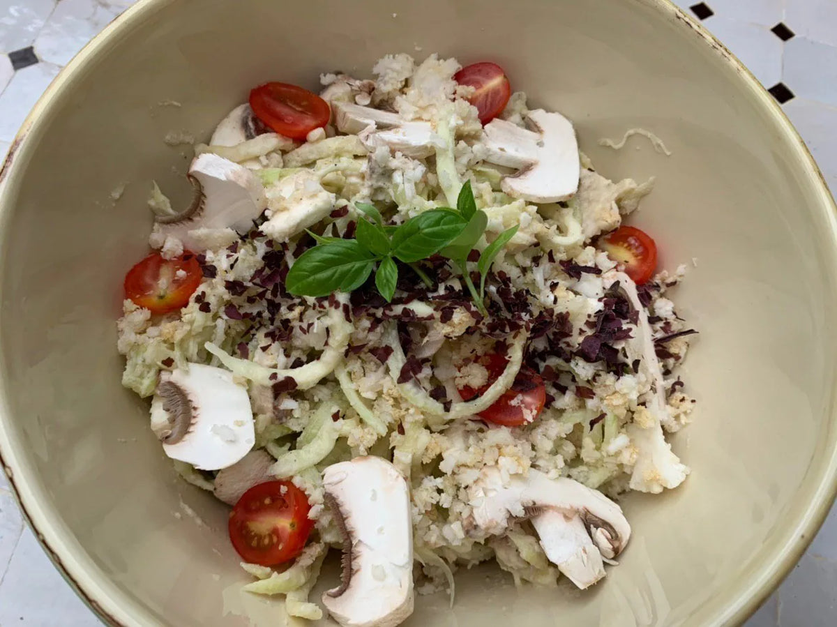 Zucchini-Pasta Alfredo mit Champignons, Cherrytomaten und Basilikum in einer Schale