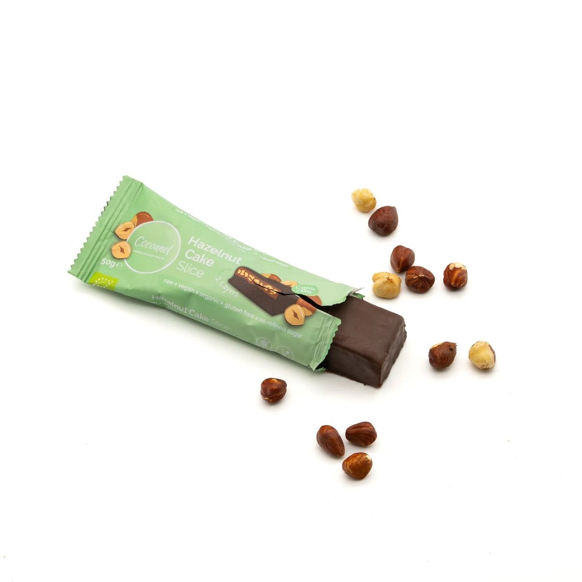 Hazelnut Cake Slice: angebrochener Riegel in Verpackung mit Haselnüssen